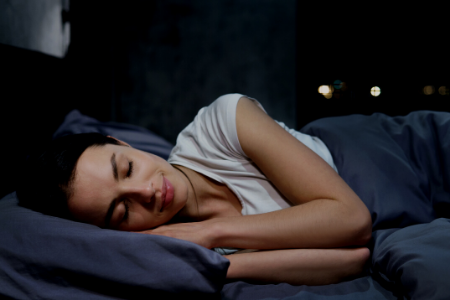 woman sleeping peacefully in the dark in her bed.