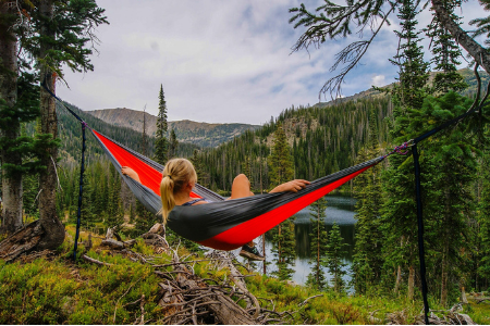 woman enjoying the view from her camping hammock on the mountaintop