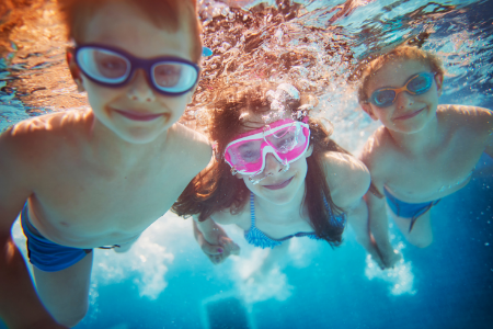 3 children swimming underwater in the pool