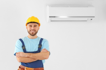 Repair person with an air conditioner, one of the appliances commonly covered with a home warranty.