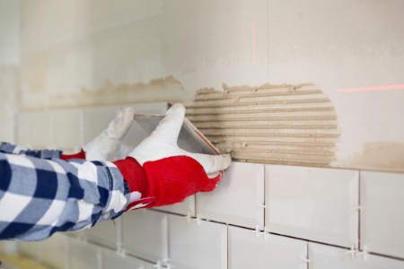 A professional tackling the complicated home improvement project of laying a tile backsplash.