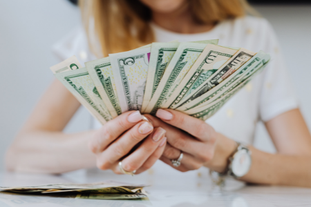 Woman counting money for her emergency fund.