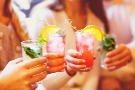 Three ladies toasting with their cocktails for the end of summer.