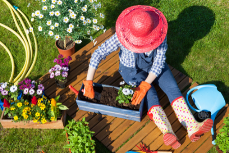 A woman potting plants in her small garden space.