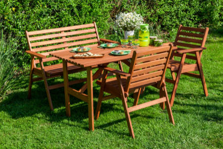 A garden set with a folding table, bench, and two chairs.