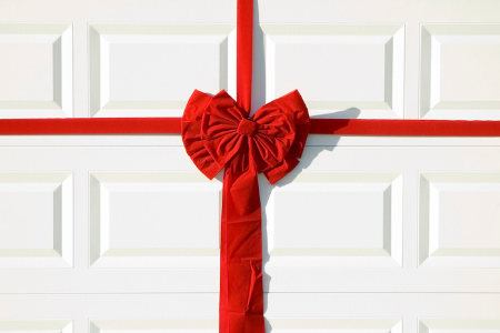 A garage door with a red bow, an easy way to decorate your home's exterior.