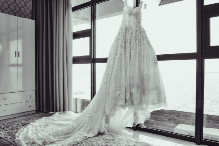 A wedding gown hanging in the window.