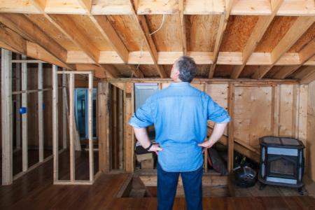 A man looking around his home addition during construction.