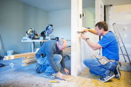 Two workers in the middle of a California home renovation.