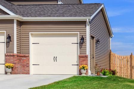 A white garage door located at the end of a home.