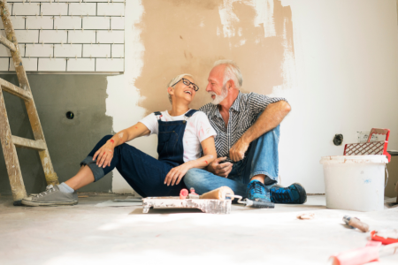 A retired couple sitting in a room in the property they are working on flipping.