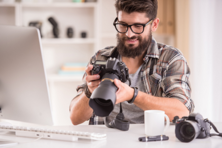 A photographer reviewing the photos he took of a rental property for sale.