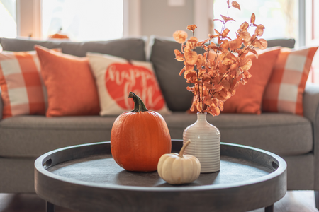 A pumpkin with dried leaves, an option for holiday decor on a budget.