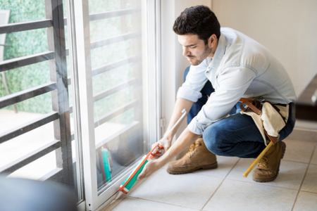 A man sealing his sliding door from drafts.