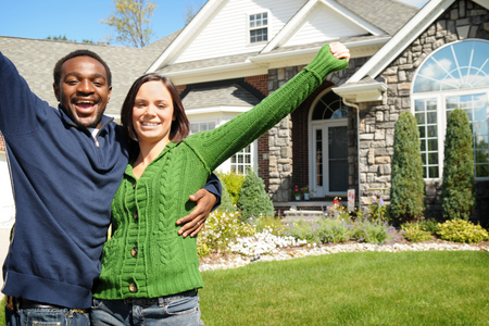 A couple standing in front of their starter home.