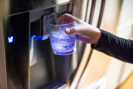 A person getting a drink from the water dispenser.