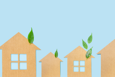 A cardboard cutout of a house with leaves, symbolizing going green.