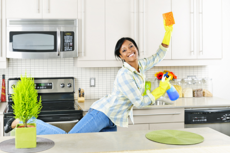 A woman celebrating after deep cleaning the kitchen in one day.