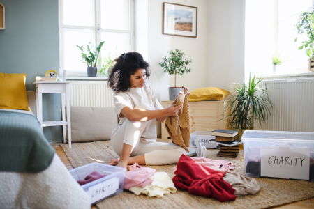 A woman decluttering, an important step in creating a healthy home environment.