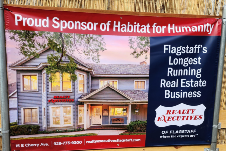 A sign showing Realty Executives of Flagstaff's sponsorship of Habitat for Humanity.