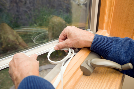Adding weatherstripping to a window, an easy step in winter-proofing your home.