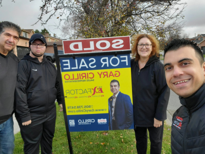 Gary Cirillo and some happy clients in front of his "Sold" yard sign.