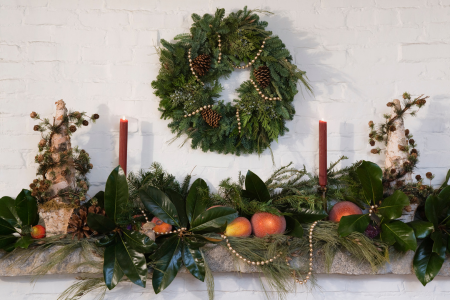 A mantle with burnt orange decor, a non-traditional holiday color scheme.