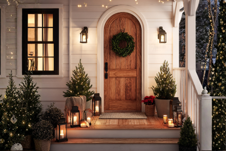 A front entryway in winter with curb appeal- natural elements, soft lighting, and a wreath on the door.