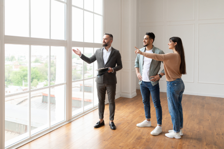 Young homebuyers admiring upgraded windows in a home.