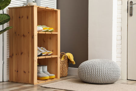 A rug and simple storage solution near an entry door is designed to reduce dirt, sand, and clutter in the home.
