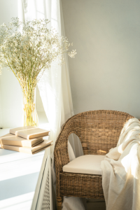 A small chair with cushions and blankets for comfort.