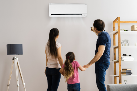 A bright living room with a family checking out the air conditioner to keep cool with a low energy bill in the summer.