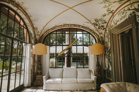 A vintage living room with a decorative ceiling and antique decor.
