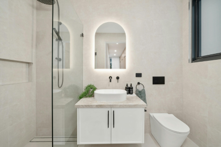 Small bathroom design tricks include using light, large tiles, decluttering, and maximizing natural light.