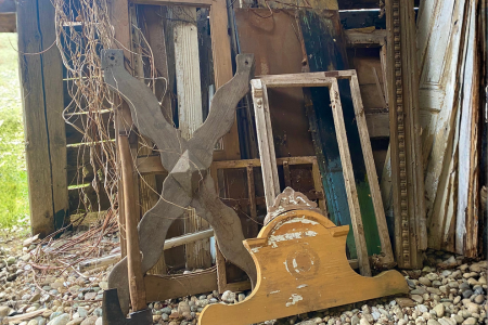 A stack of wooden doors, frames, and headboards- all reclaimed materials that can be used for home decor.