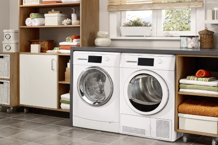 A small, organized laundry room with open shelving, bins, and a folding counter.